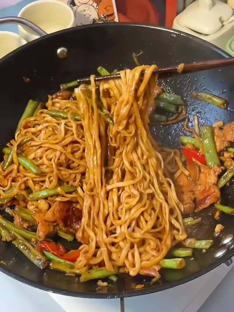 Close-up of braised noodles being served